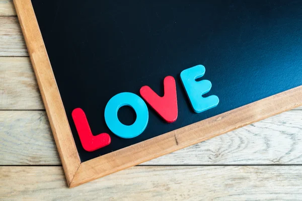 Houten woord Love op zwarte bord 3 — Stockfoto