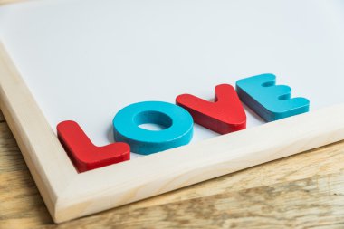 Beyaz tahta köşesinde ahşap kelime aşk