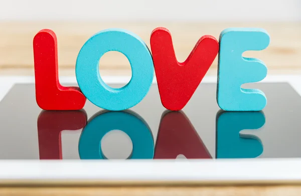 Parola di legno LOVE stand su tablet 1 — Foto Stock