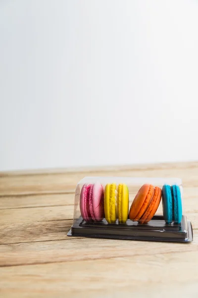 Kleurrijke macaron in plastic doos op houten vloer 2 — Stockfoto
