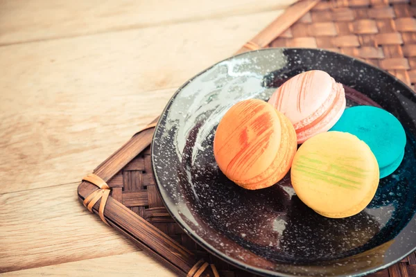 Macaron colorato in piatto nero sul pavimento in legno Tema Vintage 5 — Foto Stock