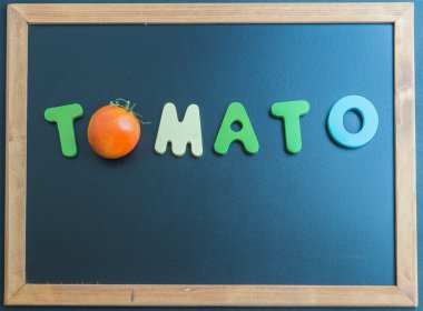 Kara tahta üzerinde domates ahşap kelime