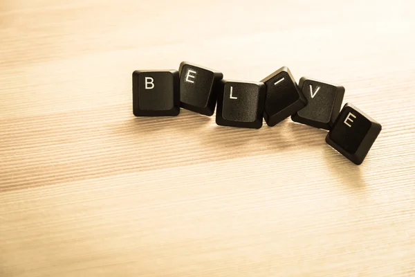 Retro tarzı ahşap zemin üzerinde belive kelime klavye — Stok fotoğraf