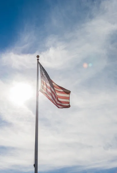 Drapeau des États-Unis d'Amérique avec ciel nuageux et fusée éclairante — Photo