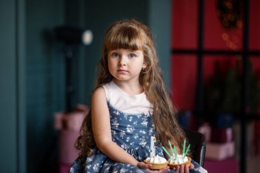 Küçük güzel kız krep yiyor. Kız pastayı tutuyor. Uzun saçlı kız. Çocuk doğum gününü kutlar