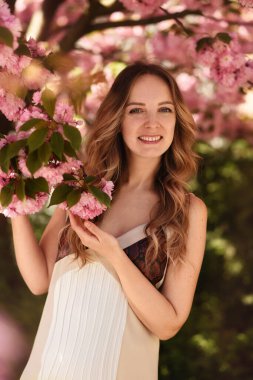 Bahar bahçesinde güzel bir genç kadın. Sakura 'nın yanındaki kız