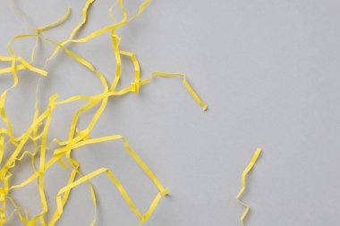 Parlak sarı dalgalı kağıt şeritli soyut gri arkaplan.