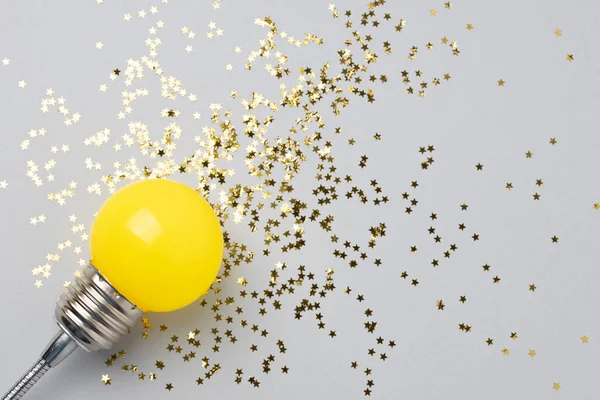 Uma lâmpada decorativa amarela em um fundo cinza. — Fotografia de Stock