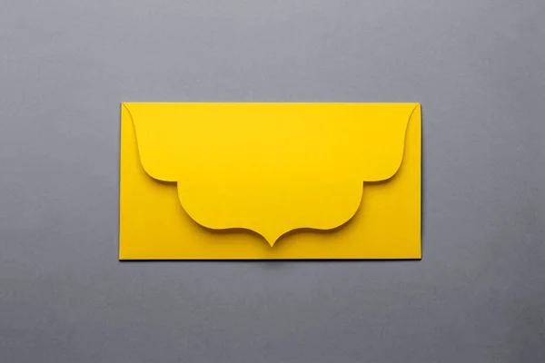 Envelope amarelo fechado sobre fundo de papel cinza. — Fotografia de Stock