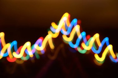 Karanlıkta çok renkli ışık çizgileri, aydınlatma, çelenk