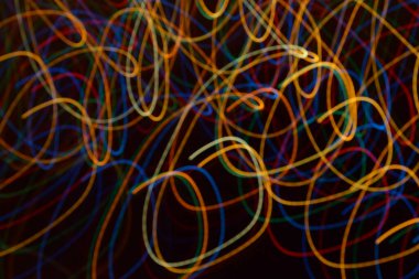 Karanlıkta çok renkli ışık çizgileri, aydınlatma, çelenk