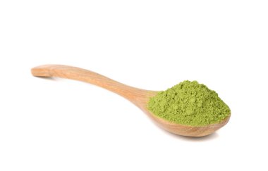 Beyaz arka planda izole edilmiş ahşap kaşıkla süslenmiş kibrit yeşili çay.