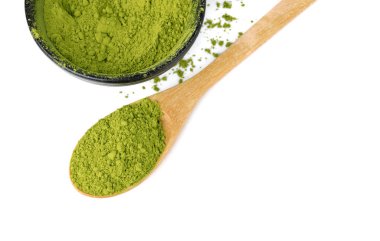 Beyaz arka planda izole edilmiş ahşap kaşıkla süslenmiş kibrit yeşili çay.