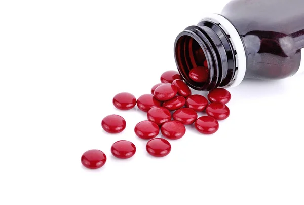 İlaç hapları, beyaz arka planda cam şişedeki haplar.