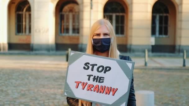 Mujer joven con máscara médica llamando para detener la tiranía sosteniendo vapor — Vídeos de Stock