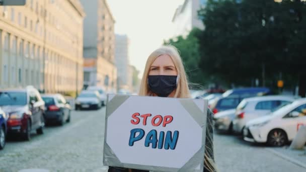 Женщина в защитной маске протестует, чтобы остановить боль, удерживая пароход — стоковое видео
