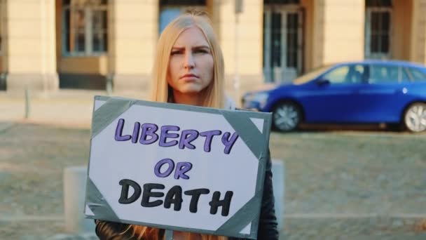 Mujer rubia con pancarta de protesta llamando a elegir libertad o muerte — Vídeos de Stock