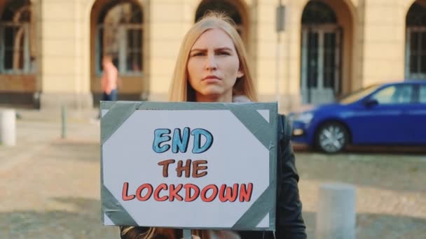 Mujer joven pidiendo terminar el bloqueo en marcha de protesta — Vídeos de Stock