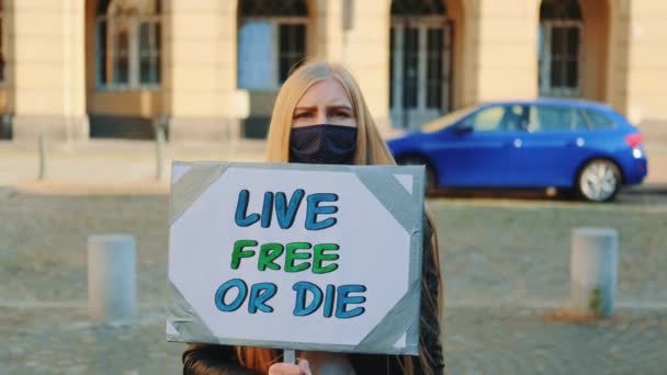 Vrouw met masker met protestspandoek die roept om vrij te leven of te sterven — Stockvideo