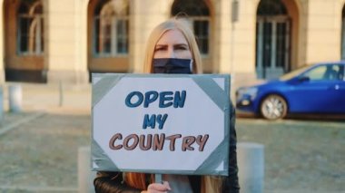 Genç bir kadın ülkeyi protesto yürüyüşü için arıyor.