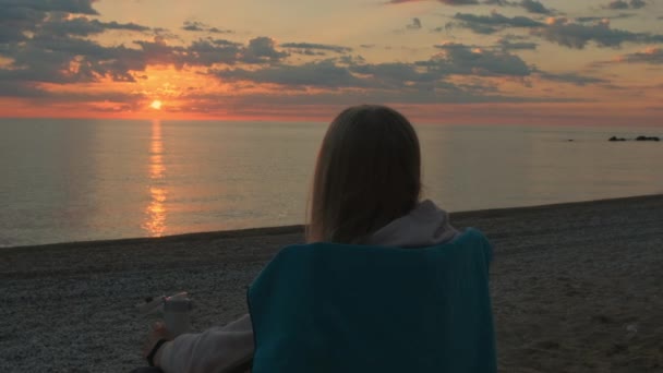 Close-up shot of girl sitting on camping chair and drinking coffee — Stock Video