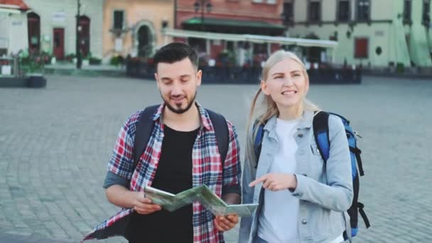 Hombre y mujer con mapa en busca de nuevo lugar histórico en el centro de la ciudad — Vídeos de Stock