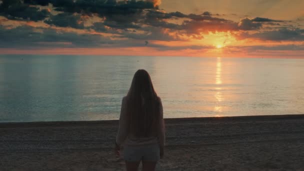 Mediana toma de mujer caminando hacia el mar y levantando las manos — Vídeos de Stock