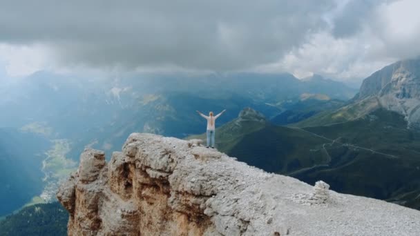 Fantastic landscape of mountain rocks and woman standing on the top with outstretched hands — Stock Video