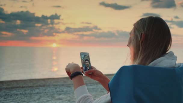 Junge Frau telefoniert mit Smartphone am Strand mit Freundin — Stockvideo