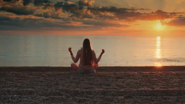 Женщина медитирует на берегу моря — стоковое видео
