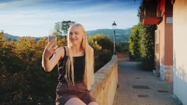 Ładna kobieta robi selfie na smartfonie przed pięknym krajobrazem natury — Wideo stockowe