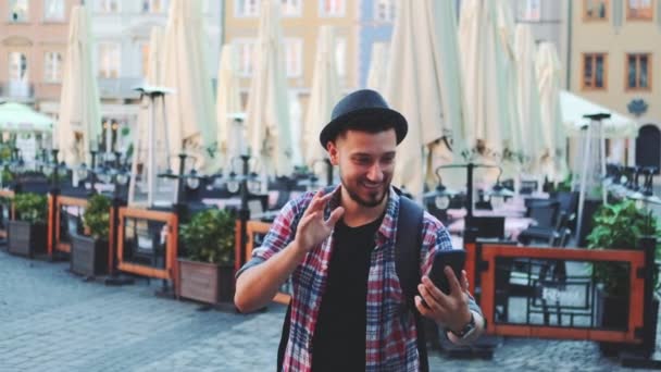Turista guapo haciendo videollamada en smartphone y mostrando su lugar de visita — Vídeos de Stock