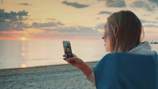 Mujer joven haciendo videollamada a su amigo con smartphone en la playa — Vídeos de Stock