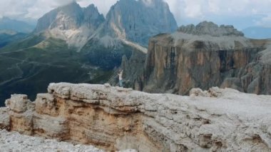 İnanılmaz dağların manzarası, kadın uzanmış elleriyle tepede duruyor.