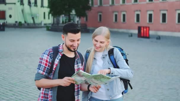 Туристы с картой в поисках нового исторического места в центре города — стоковое видео