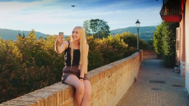 Güzel bayan, güzel doğa manzarasının önünde akıllı telefondan selfie çekiyor. — Stok video