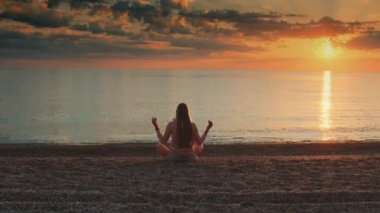 Deniz kıyısında meditasyon yapan bir kız