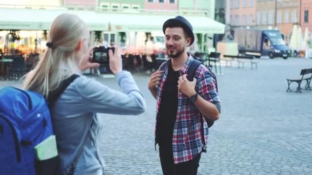 Пара туристов, делающих фотографии с фотокамерой на исторической рыночной площади — стоковое видео