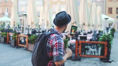 Başka bir yerden gelen kadın turistle akıllı telefondan görüntülü konuşma yapan bir adam.