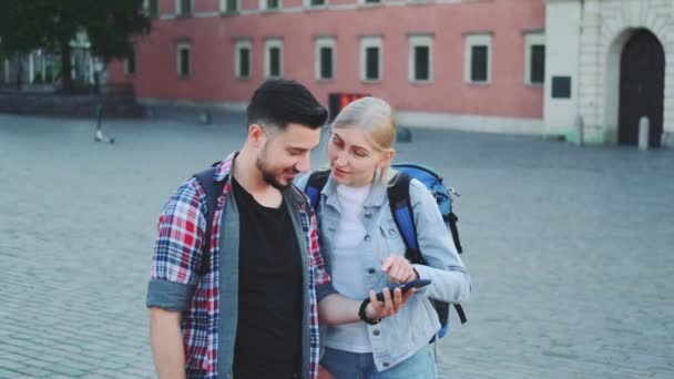 Felices turistas con teléfono inteligente encontrar hermoso lugar en el centro de la vieja ciudad europea — Vídeos de Stock