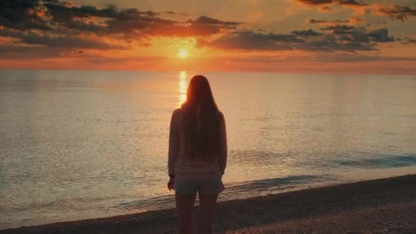 Admiring sunrise on seashore woman raising up her hands — Stock Video