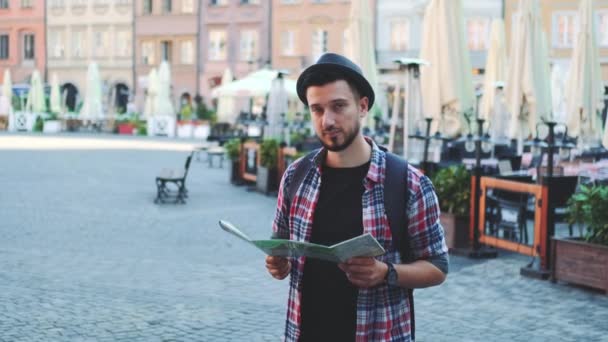 Captura de zoom de turista joven de moda con mapa sonriendo a la cámara — Vídeos de Stock