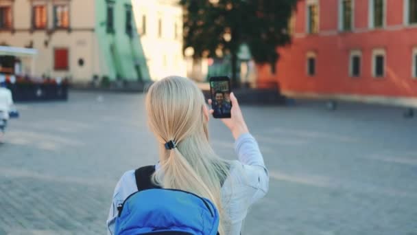 Vissza a nézetet a női turista, hogy video hívás okostelefonon barátjával más helyről — Stock videók