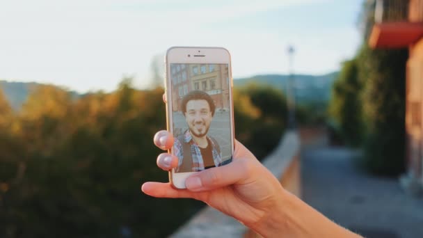 Närbild av kvinnor hand hålla smartphone och ge videosamtal med mannen — Stockvideo