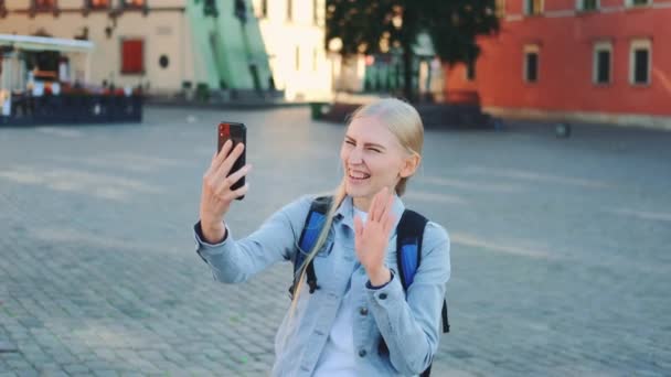 Красивая туристка делает видеозвонок на смартфон с места своего визита — стоковое видео