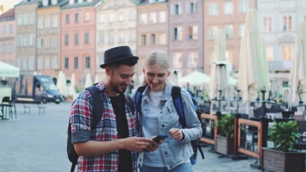 Pareja joven de turistas utilizando el teléfono inteligente y admirando hermosos alrededores — Vídeos de Stock