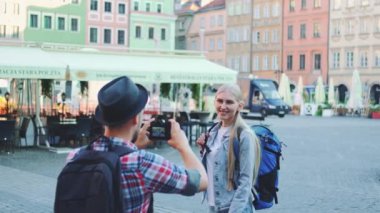 Genç turist çift tarihi binaların manzarasında fotoğraf çekiyor.