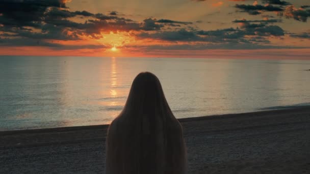 Woman walking to the sea and raising her hands up — Stock Video