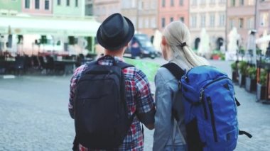 Çantalı bir adam ve kadın Central City meydanında harita kontrol ediyorlar.