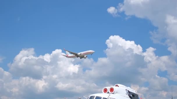 Пассажирский самолет, летящий в голубом небе с белыми облаками — стоковое видео